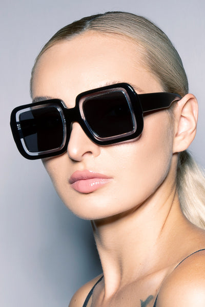 Model wearing our Futura oversize square sunglasses three quarter view.