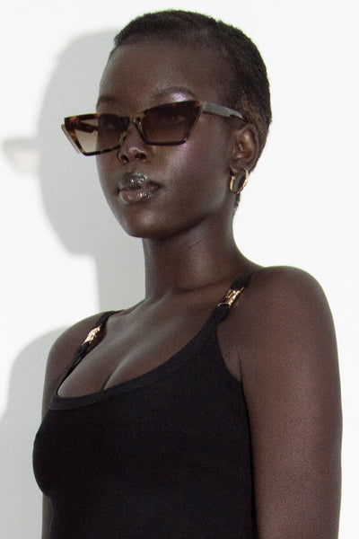 Model wearing our Fia tortoise shell cateye sunglasses three quarter front view.