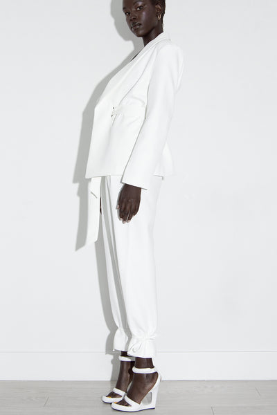 Model wearing our Calla white blazer and pant suit pant legs tied side view.